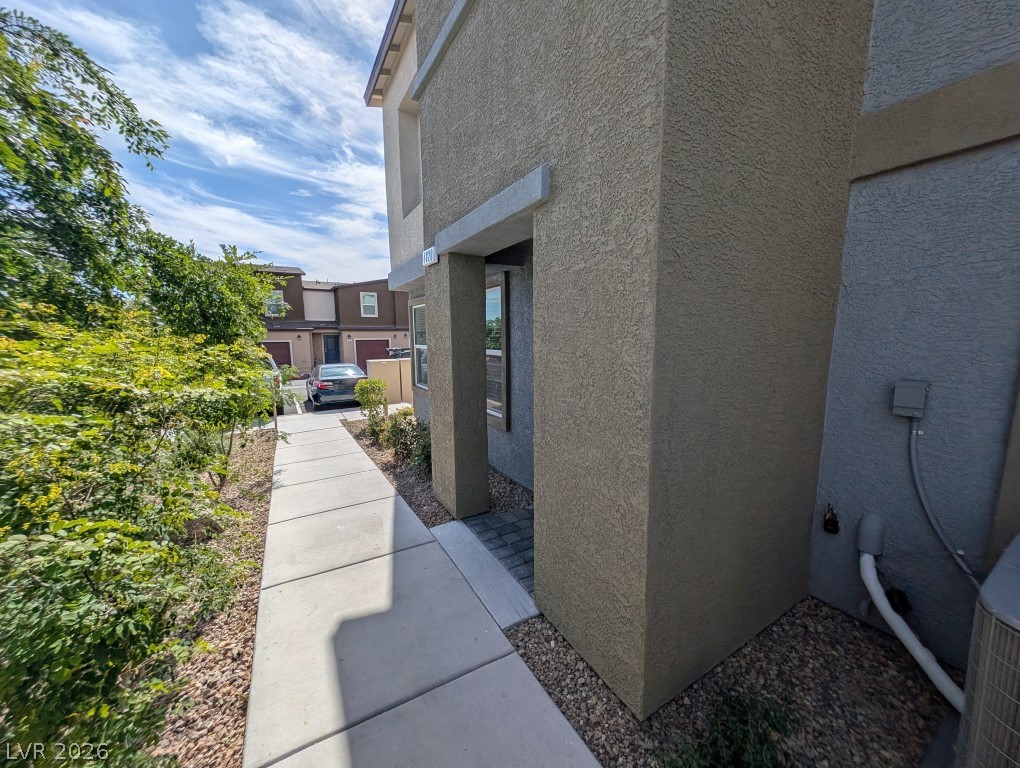 4820 Orchid Rdg Avenue Las Vegas, NV 89141 - Photo 3 of 16 A welcoming walkway leads to a textured stucco exterior, promising modern desert living.