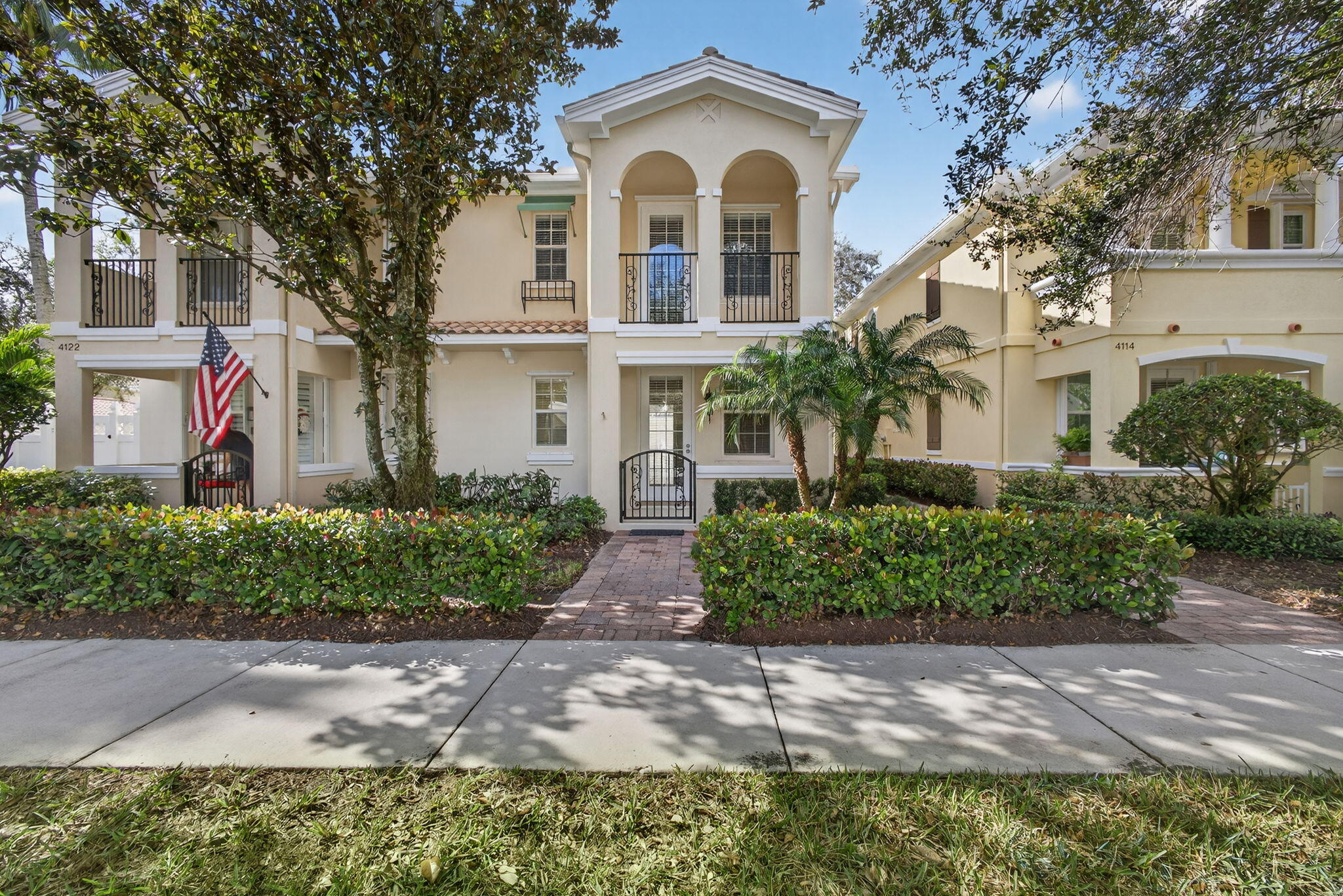 4118 Parkside Drive Jupiter, FL 33458 - Photo 4 of 73 a front view of a white house with a yard and plants