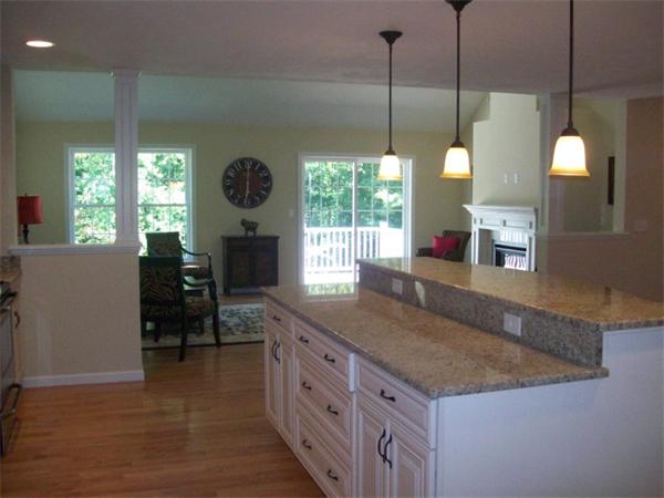 20 Riley Road, Unit 11 Lunenburg, MA 01462 - Photo 5 of 8 a kitchen with kitchen island a counter top a stove and a wooden floors
