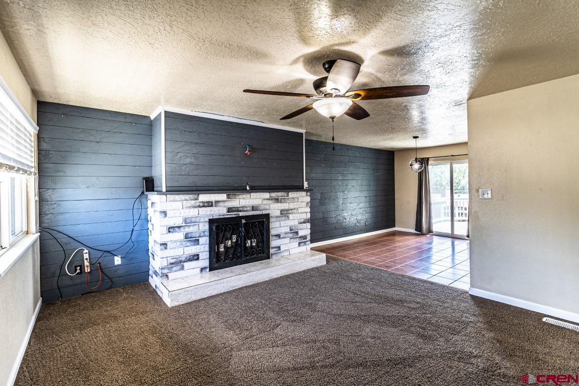 5705 Ravella Drive Farmington, NM 87402 - Photo 13 of 35 a view of an empty room with a fireplace and a window