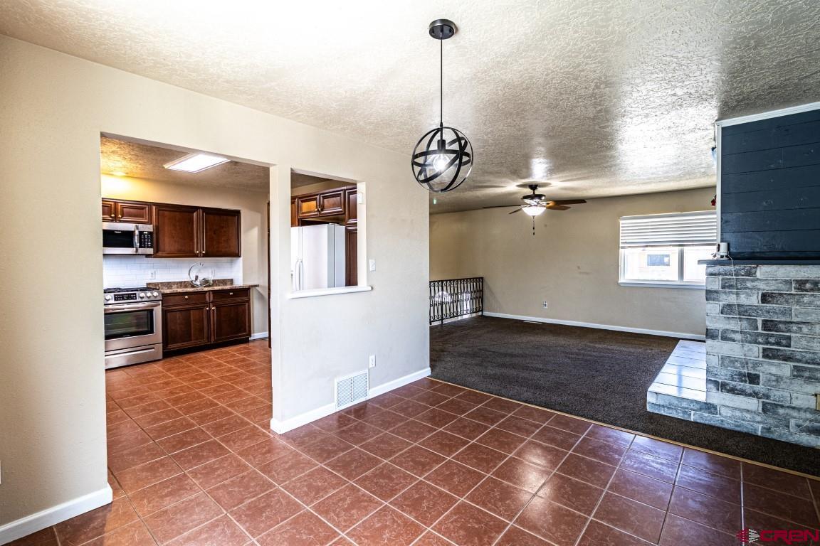 5705 Ravella Drive Farmington, NM 87402 - Photo 10 of 35 a kitchen with stainless steel appliances granite countertop a sink stove and refrigerator