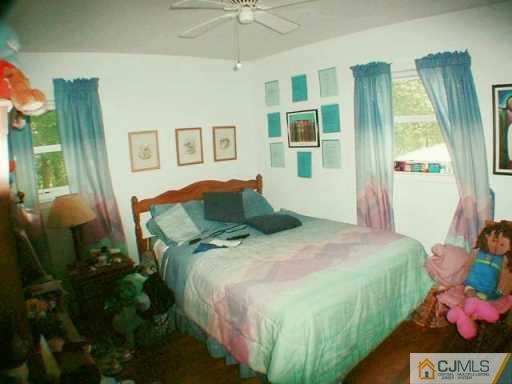 5 Conerly Road Somerset, NJ 08873 - Photo 7 of 8 a bed sitting in a bedroom next to a window