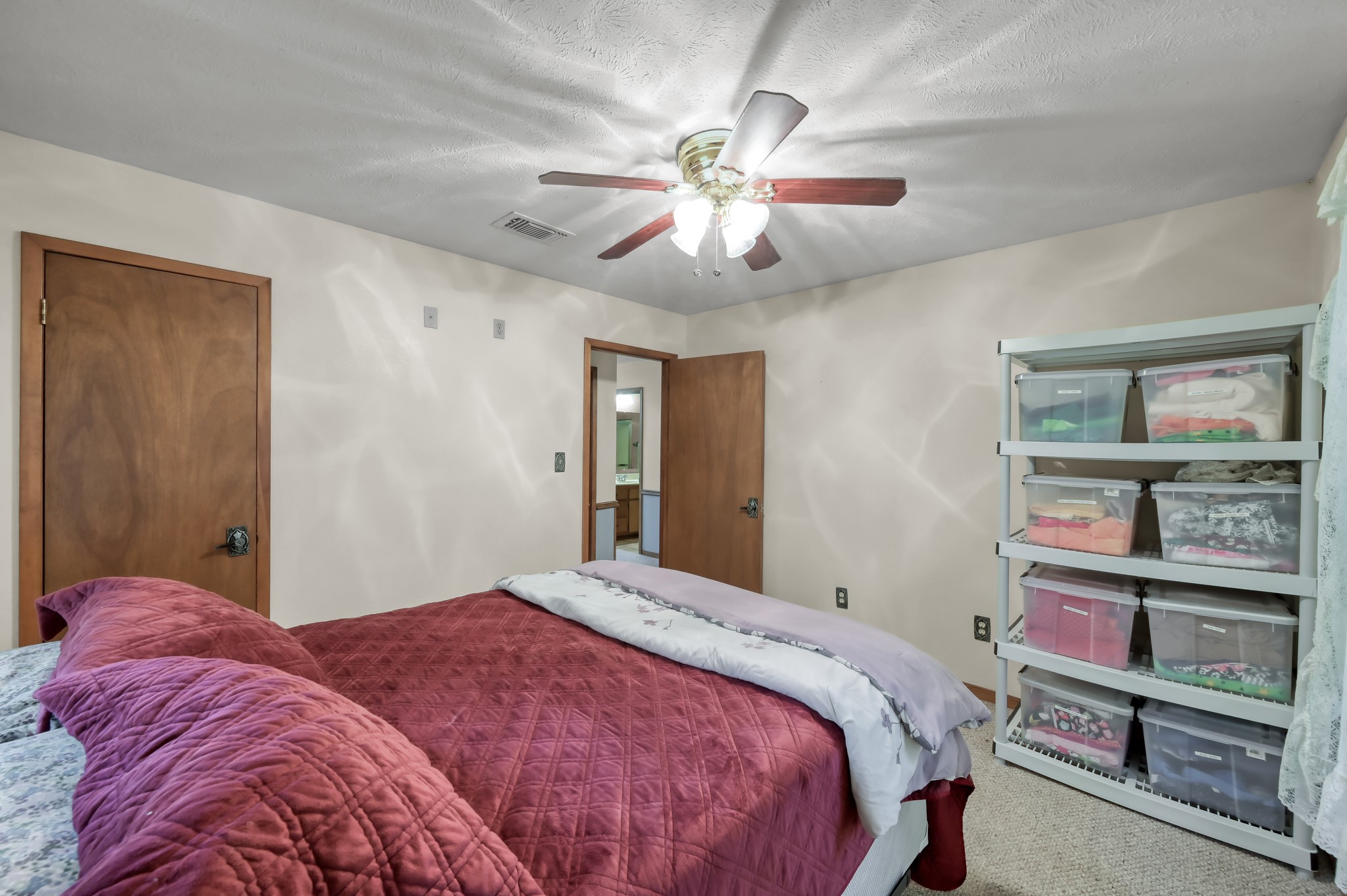 254 Sharp Lane Trinity, TX 75862 - Photo 22 of 36 a bedroom with a large bed and a chandelier