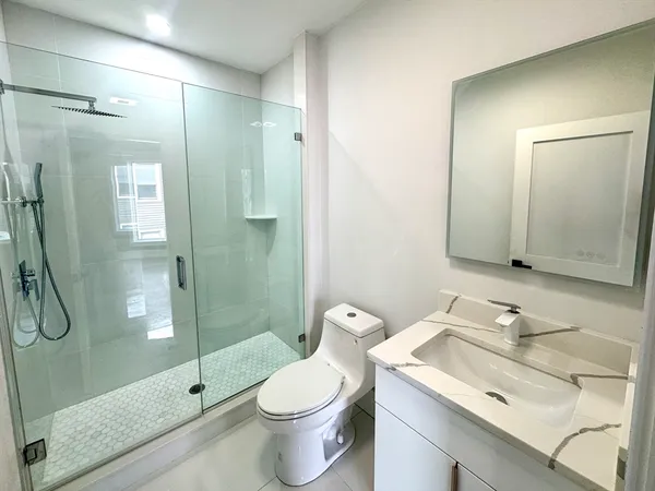 a bathroom with a granite countertop sink toilet and shower