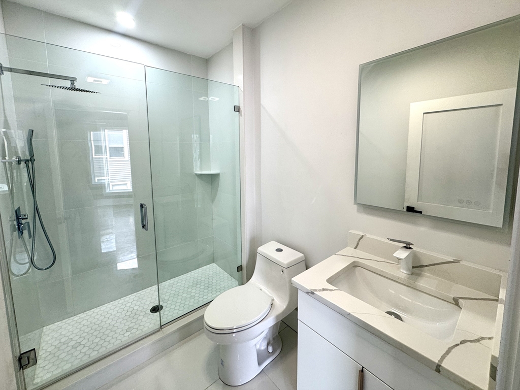 567 Park Street, Unit 3 Boston, MA 02124 - Photo 9 of 11 a bathroom with a granite countertop sink toilet and shower