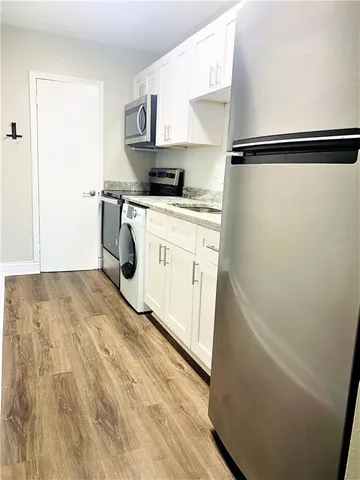 a kitchen with a refrigerator a sink and cabinets