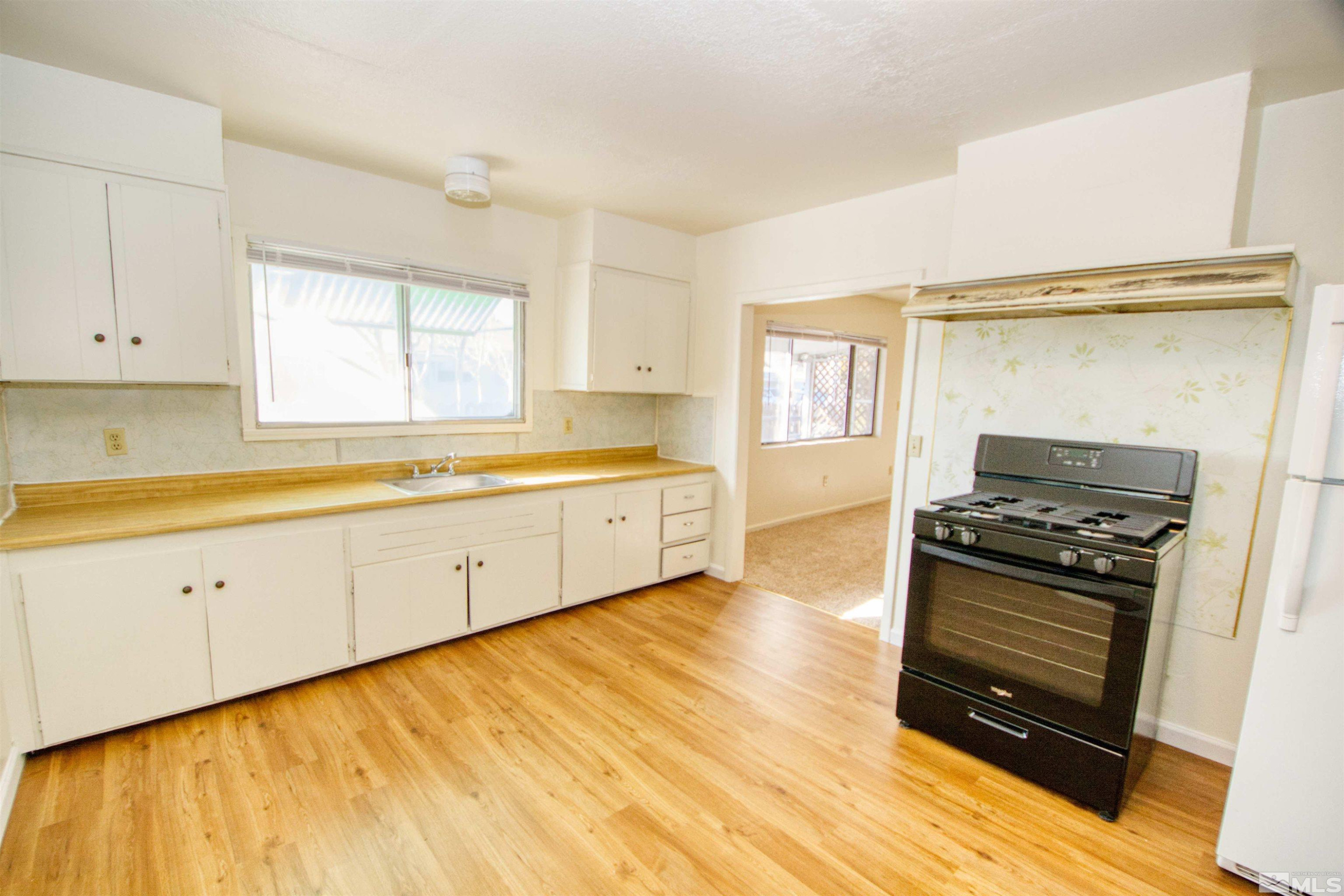 4300 Reno Highway, Unit 1 Fallon, NV 89406 - Photo 2 of 12 a kitchen with stainless steel appliances a stove a sink and white cabinets