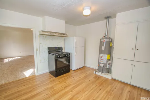 a kitchen with granite countertop a refrigerator and a stove top oven
