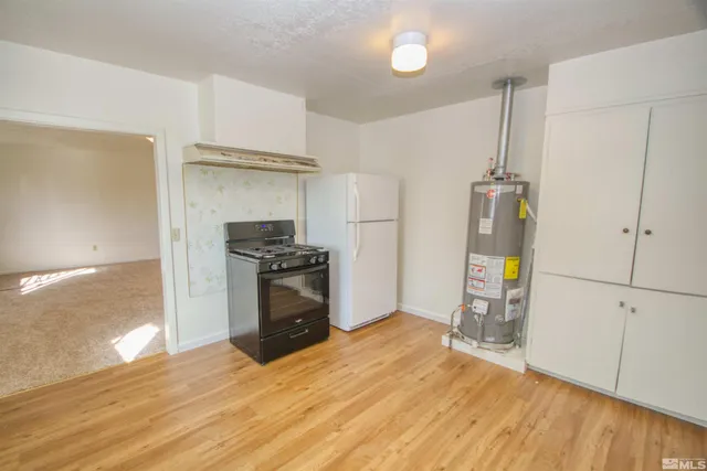 a kitchen with granite countertop a refrigerator and a stove top oven