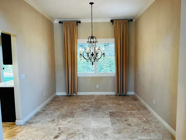 a view of an empty room with wooden floor fireplace and a window