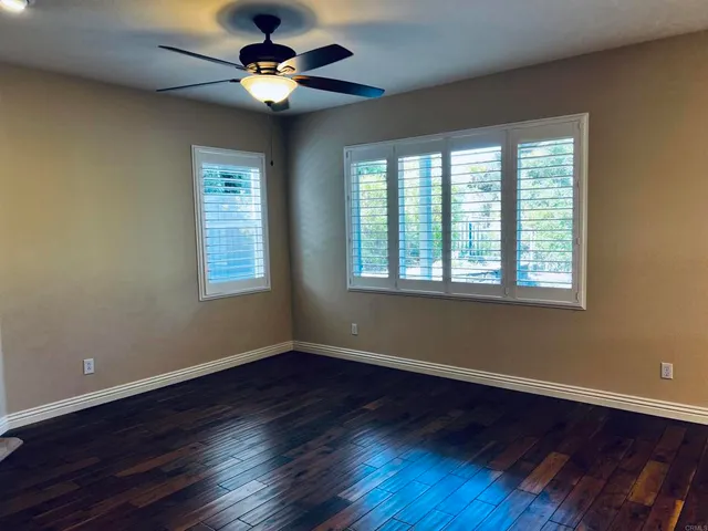 a view of a room with wooden floor and a bathroom
