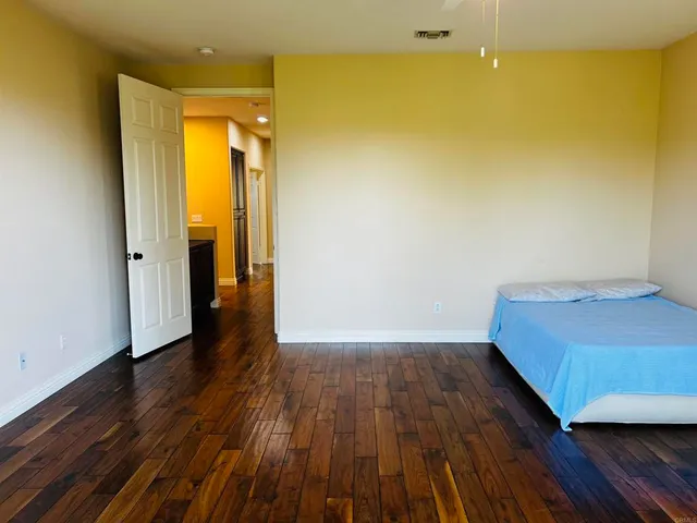 an empty room with wooden floor and windows