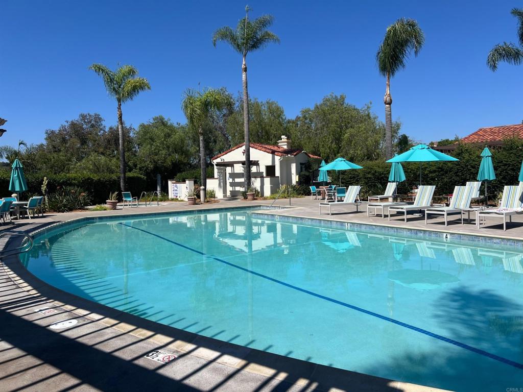 2834 Rancho Pancho Carlsbad, CA 92009 - Photo 70 of 73 a view of a swimming pool with a table and chairs under an umbrella