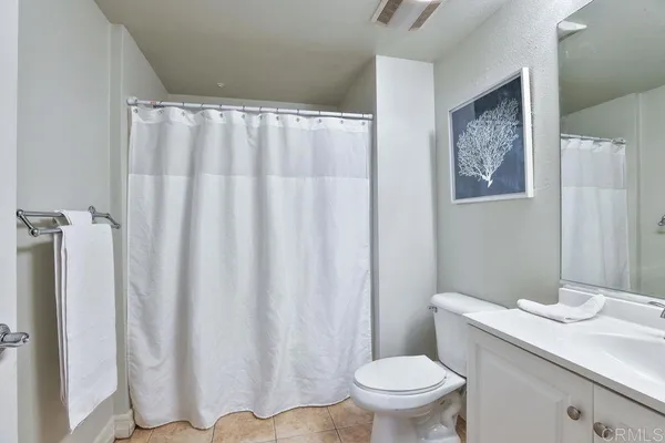 a bathroom with a granite countertop sink and a toilet