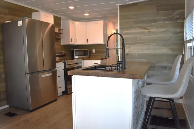 a kitchen with stainless steel appliances granite countertop a refrigerator and a stove