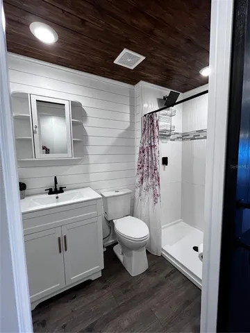 a bathroom with a sink toilet a mirror and shower