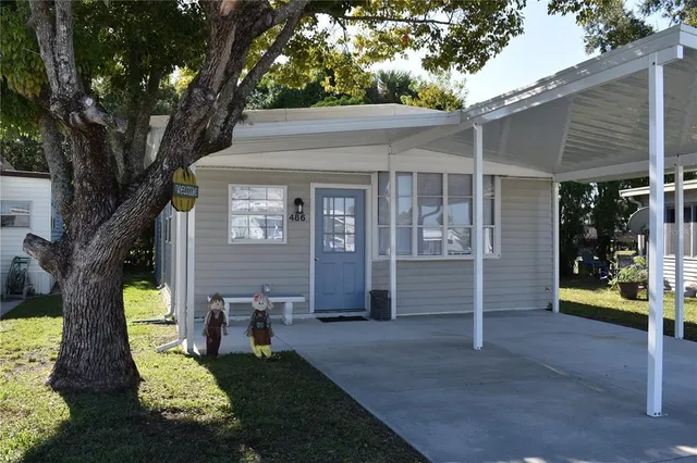 a view of a house with backyard and a tree