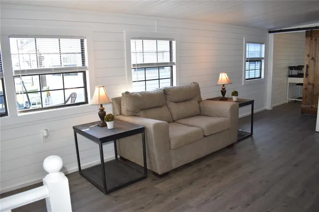 a view of a room with furniture and wooden floor