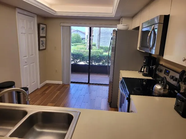 a kitchen with a sink a refrigerator and a window