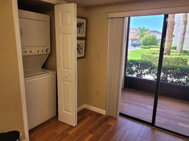 a view of a hallway with wooden floor and a living room