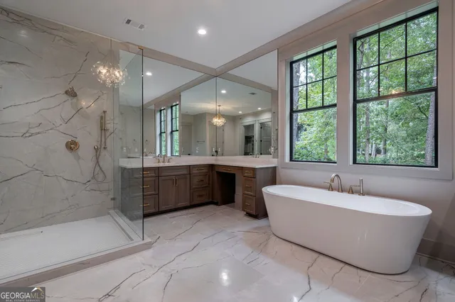 an empty room with chandelier fan and windows