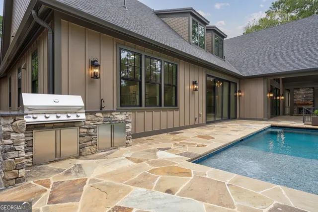 a view of swimming pool with lawn chairs and plants