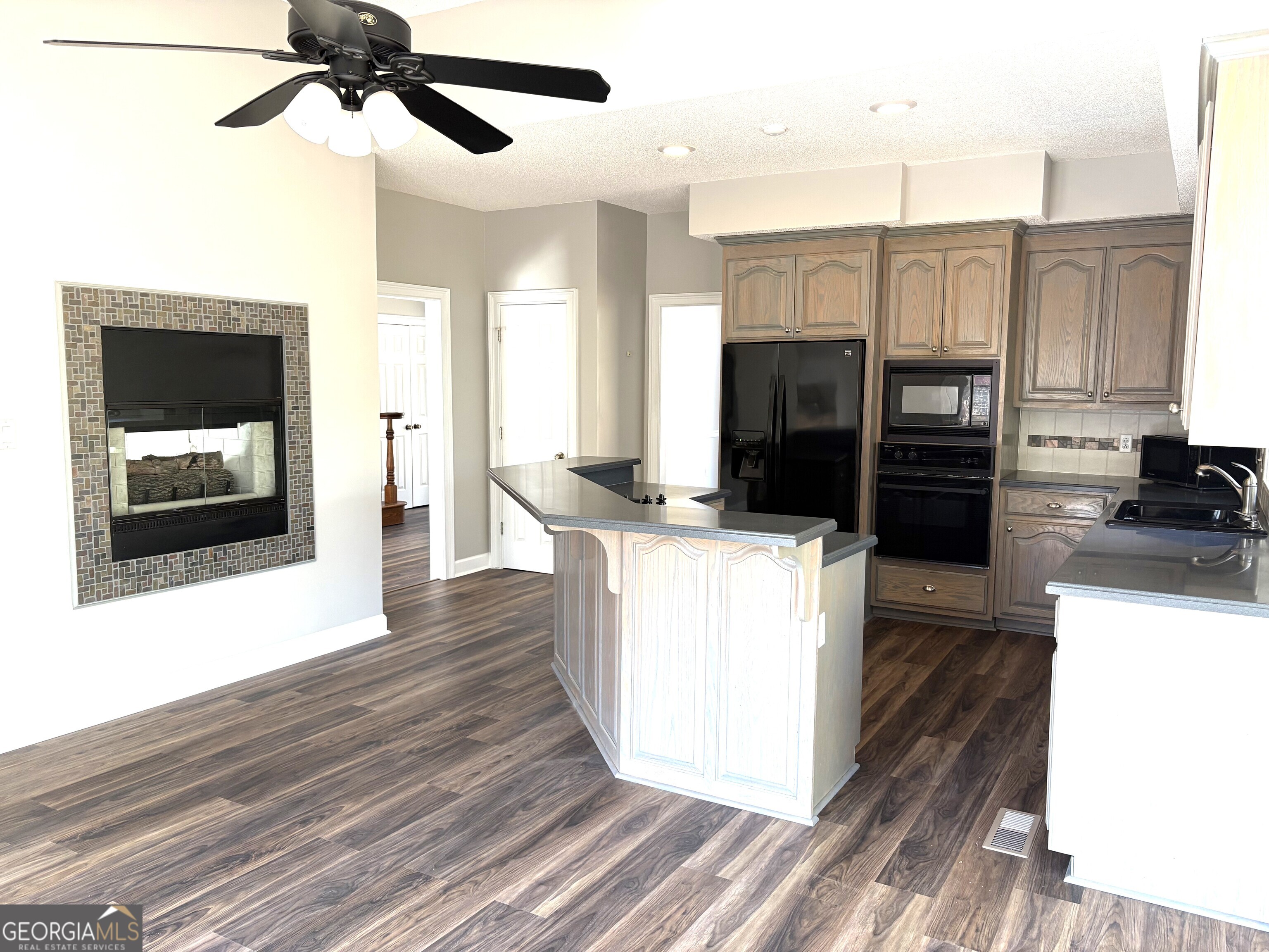 245 Woodland Street Dublin, GA 31021 - Photo 11 of 48 a kitchen with stainless steel appliances kitchen island granite countertop a refrigerator and a stove top oven
