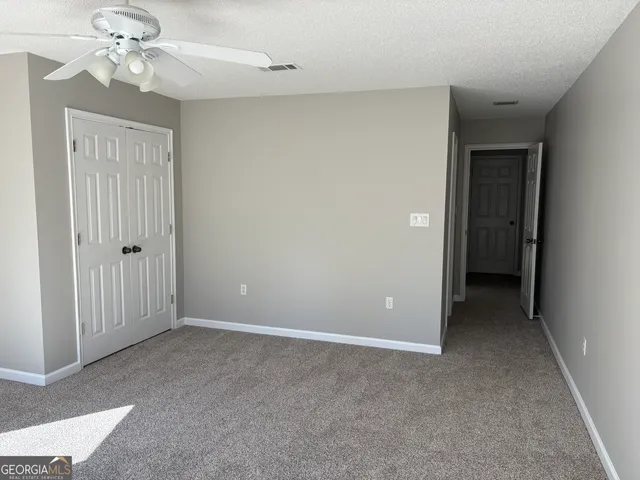 an empty room with windows and entrance to other room