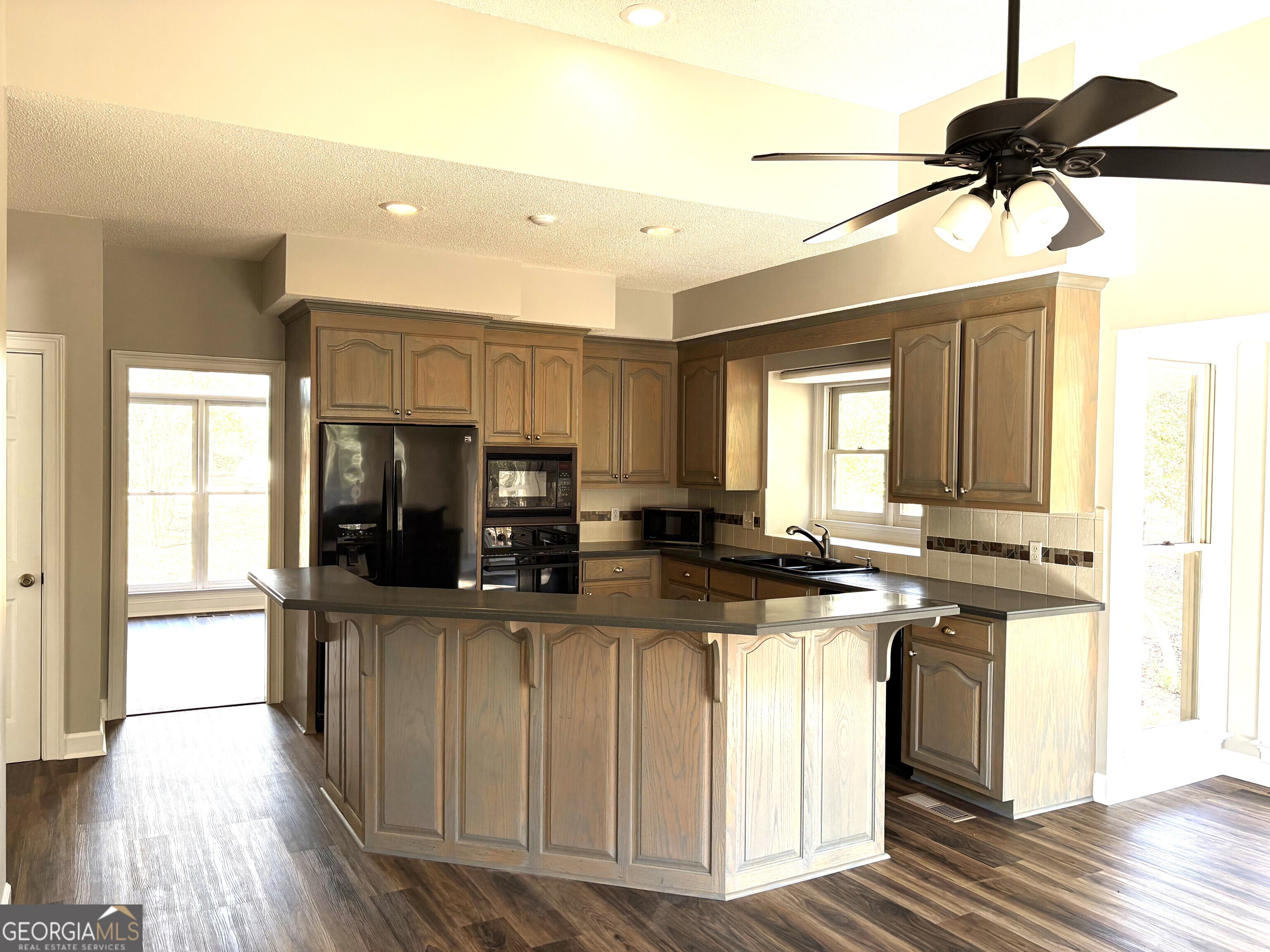 245 Woodland Street Dublin, GA 31021 - Photo 7 of 48 a kitchen with stainless steel appliances granite countertop a stove a sink and a refrigerator with wooden floor