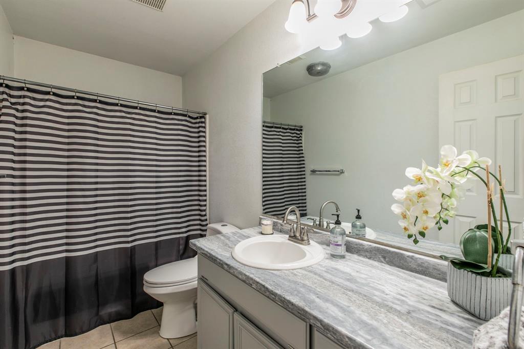 1815 Riata Drive Woodway, TX 76712 - Photo 16 of 25 a bathroom with a granite countertop sink a toilet and a mirror