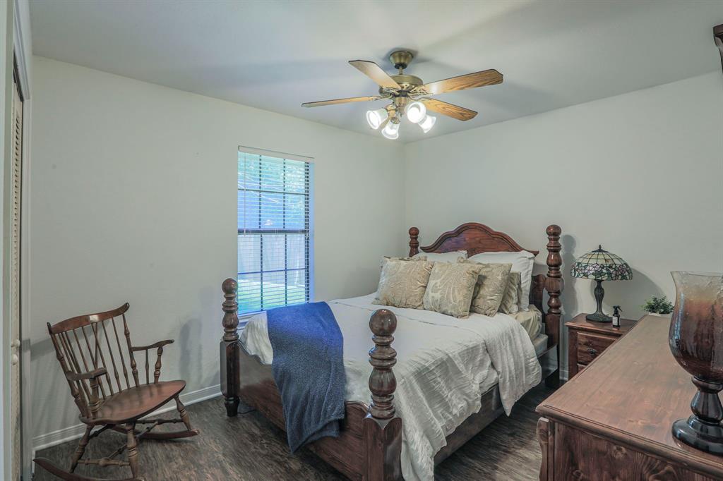 1815 Riata Drive Woodway, TX 76712 - Photo 17 of 25 a bedroom with a bed and a chandelier