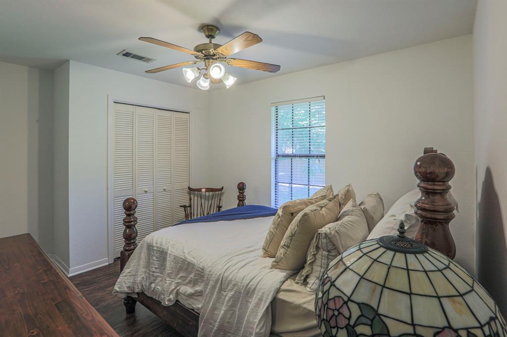 1815 Riata Drive Woodway, TX 76712 - Photo 18 of 25 a bedroom with a bed and a chandelier