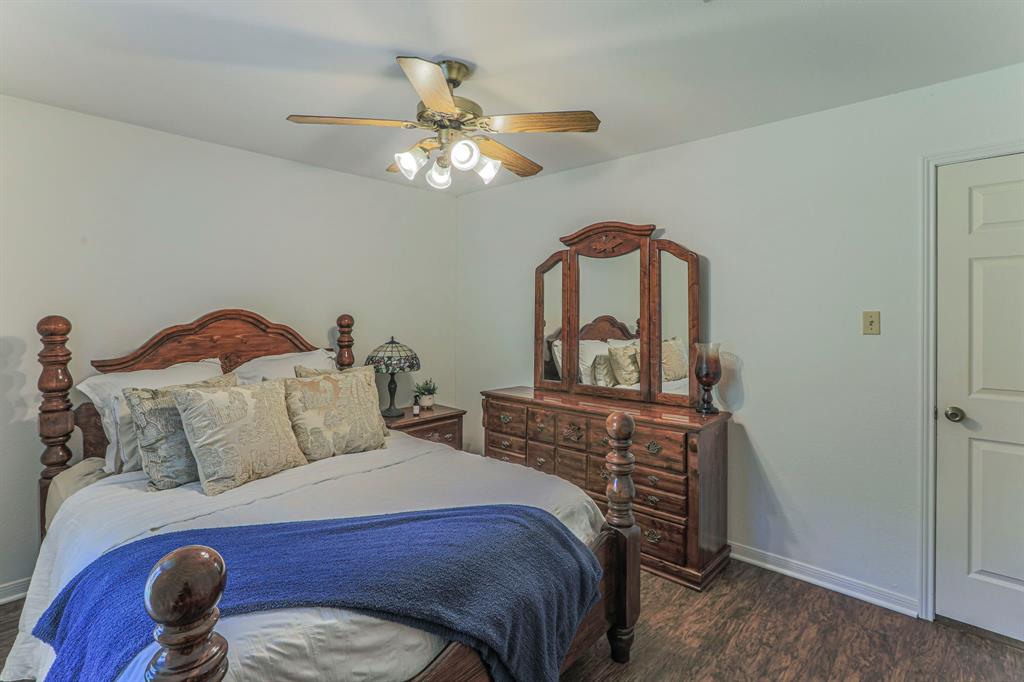 1815 Riata Drive Woodway, TX 76712 - Photo 19 of 25 a bedroom with a bed a dresser and chair