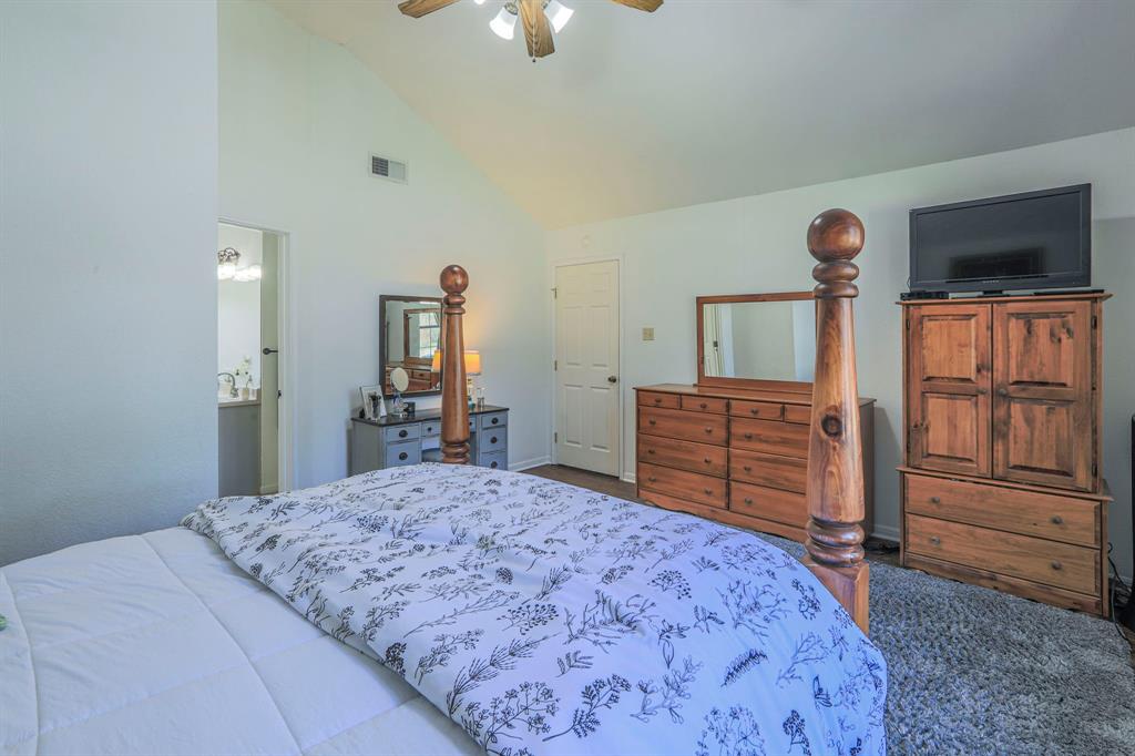 1815 Riata Drive Woodway, TX 76712 - Photo 10 of 25 a bedroom with a bed dresser and a flat tv screen