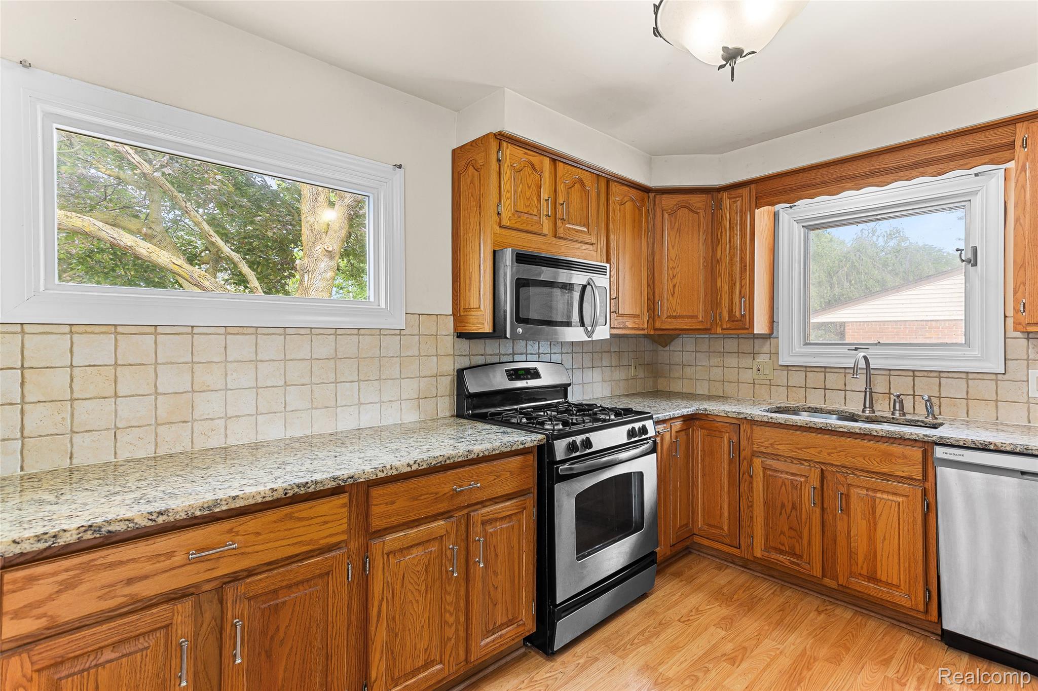 2345 Middlefield Road Trenton, MI 48183 - Photo 12 of 42 Kitchen featuring light wood cabinetry, stone-finish countertops, and a tiled backsplash