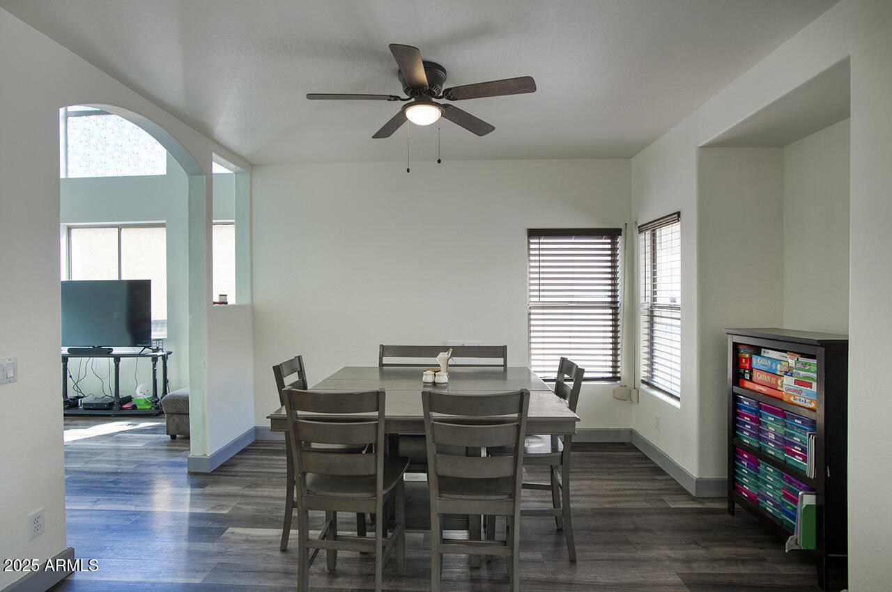 10617 West Coronado Road Avondale, AZ 85392 - Photo 10 of 32 a view of a dining room with furniture a rug and wooden floor
