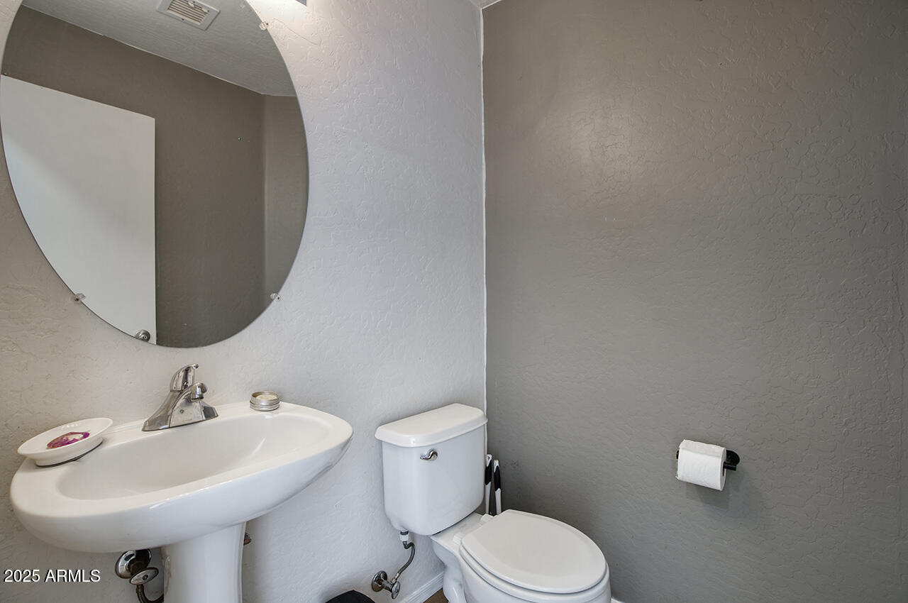 10617 West Coronado Road Avondale, AZ 85392 - Photo 11 of 32 a bathroom with a sink a toilet and mirror