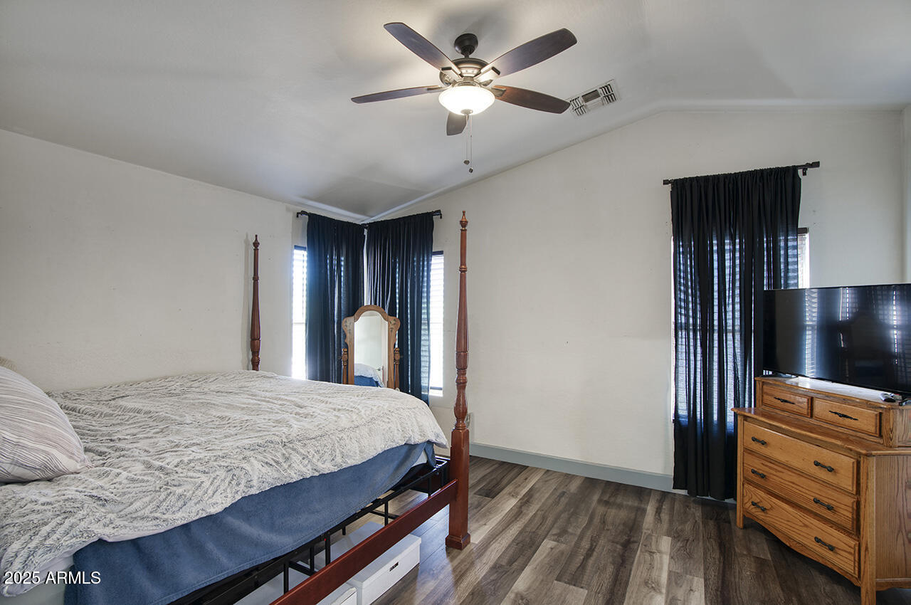 10617 West Coronado Road Avondale, AZ 85392 - Photo 14 of 32 a bedroom with a bed and a flat tv screen on dresser