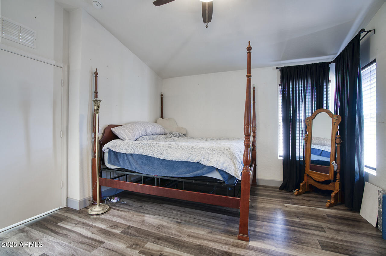 10617 West Coronado Road Avondale, AZ 85392 - Photo 15 of 32 a bedroom with a bed and wooden floor