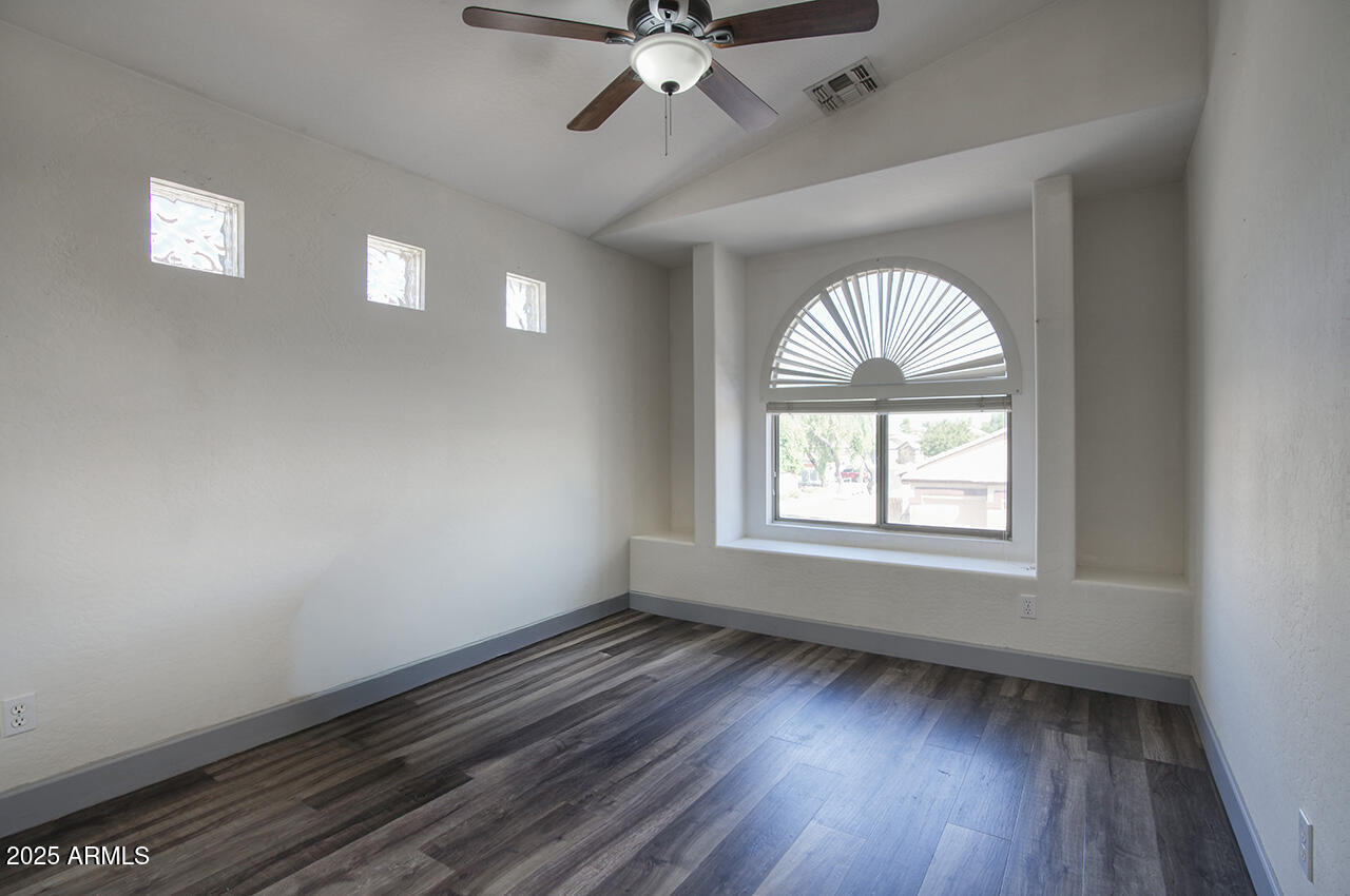 10617 West Coronado Road Avondale, AZ 85392 - Photo 18 of 32 an empty room with wooden floor fan and windows