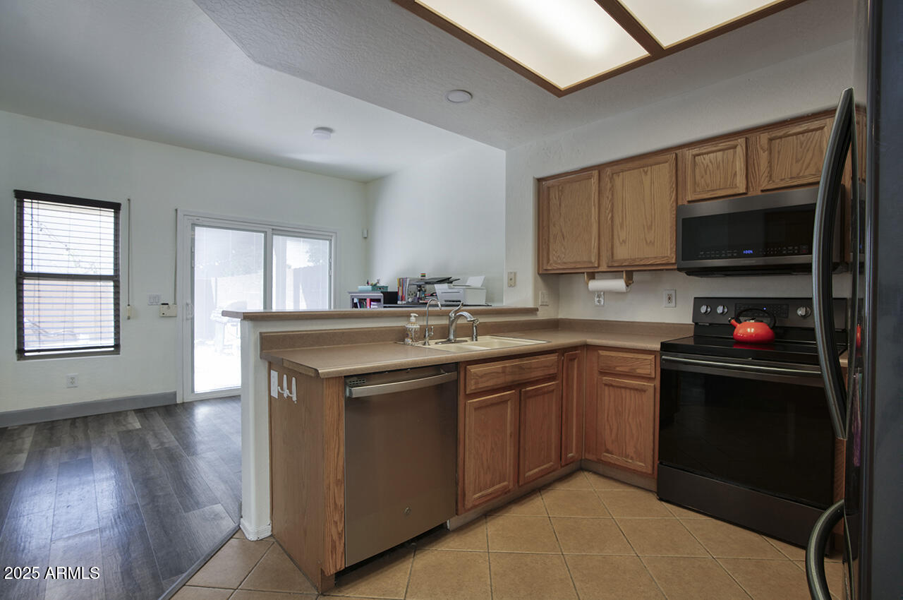 10617 West Coronado Road Avondale, AZ 85392 - Photo 6 of 32 a kitchen with stainless steel appliances granite countertop a sink stove and microwave
