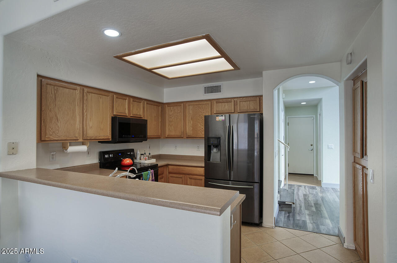 10617 West Coronado Road Avondale, AZ 85392 - Photo 8 of 32 a kitchen with stainless steel appliances a refrigerator and a sink