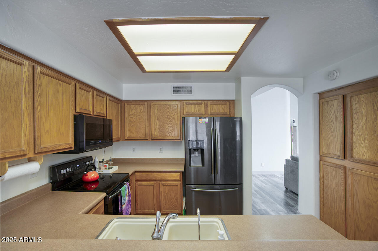 10617 West Coronado Road Avondale, AZ 85392 - Photo 9 of 32 a kitchen with a refrigerator and a sink