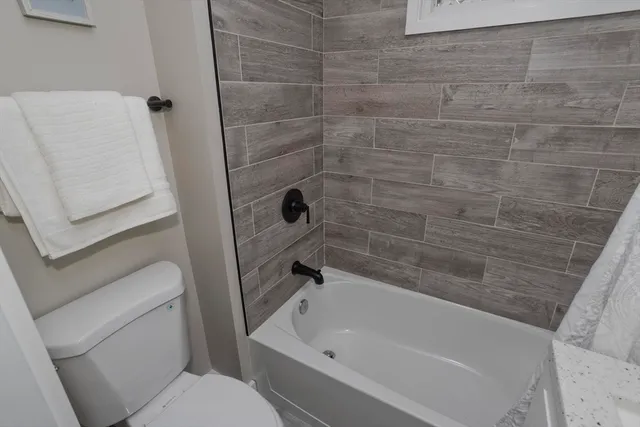 a view of a roof deck with wooden fence and a bench
