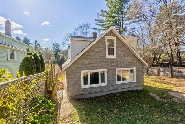 an aerial view of residential house with outdoor space and trees all around