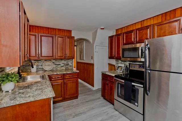 a kitchen with stainless steel appliances granite countertop a refrigerator stove and sink
