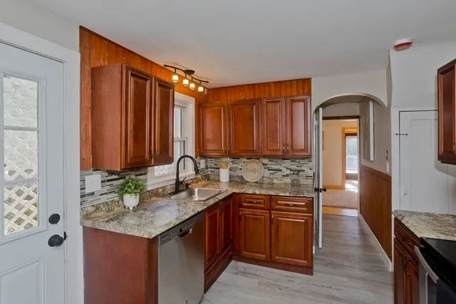 a kitchen with stainless steel appliances granite countertop a sink stove and refrigerator
