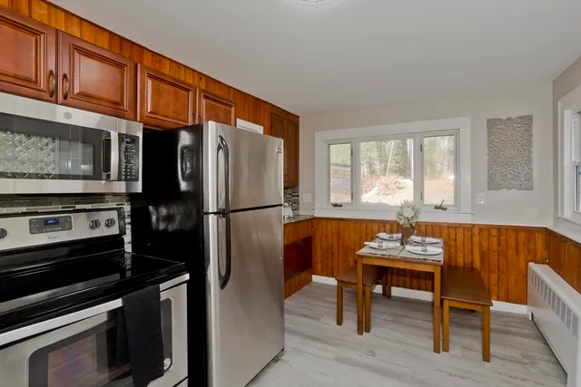 a kitchen with stainless steel appliances kitchen island granite countertop a refrigerator and a stove top oven