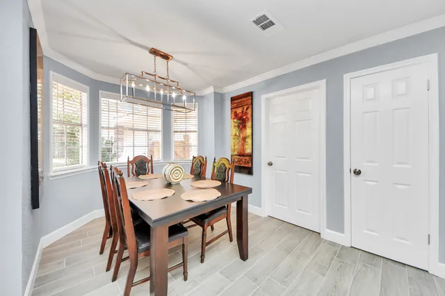 a dining room with furniture a chandelier and wooden floor