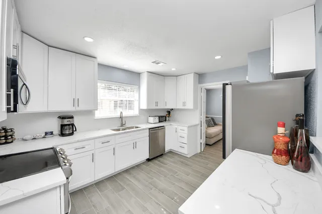 a kitchen with a sink dishwasher a refrigerator and cabinets